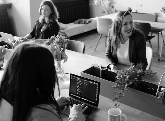 people working on laptops and laughing